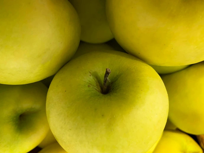 a pile of green apples sitting on top of each other